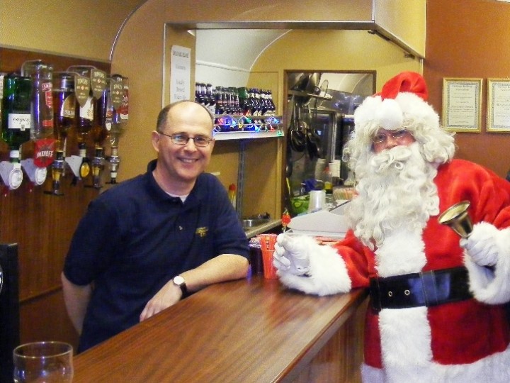 5/12/2009: Finally, the bar in action. Santa gets a warm welcome from Paul the barman on a 'Santa Special' train. (C.P.Friel)