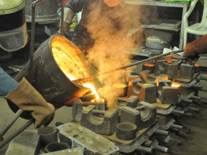 26/1/2015: A close-up of filling a mould for No.85's brake blocks, the cover of which is heavily weighed down. (C.P. Friel)